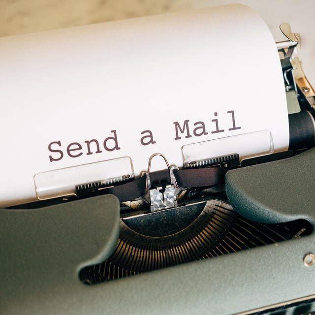 Gros plan sur une machine à écrire dans laquelle est insérée une feuille sur laquelle il est écrit « Send a Mail ».